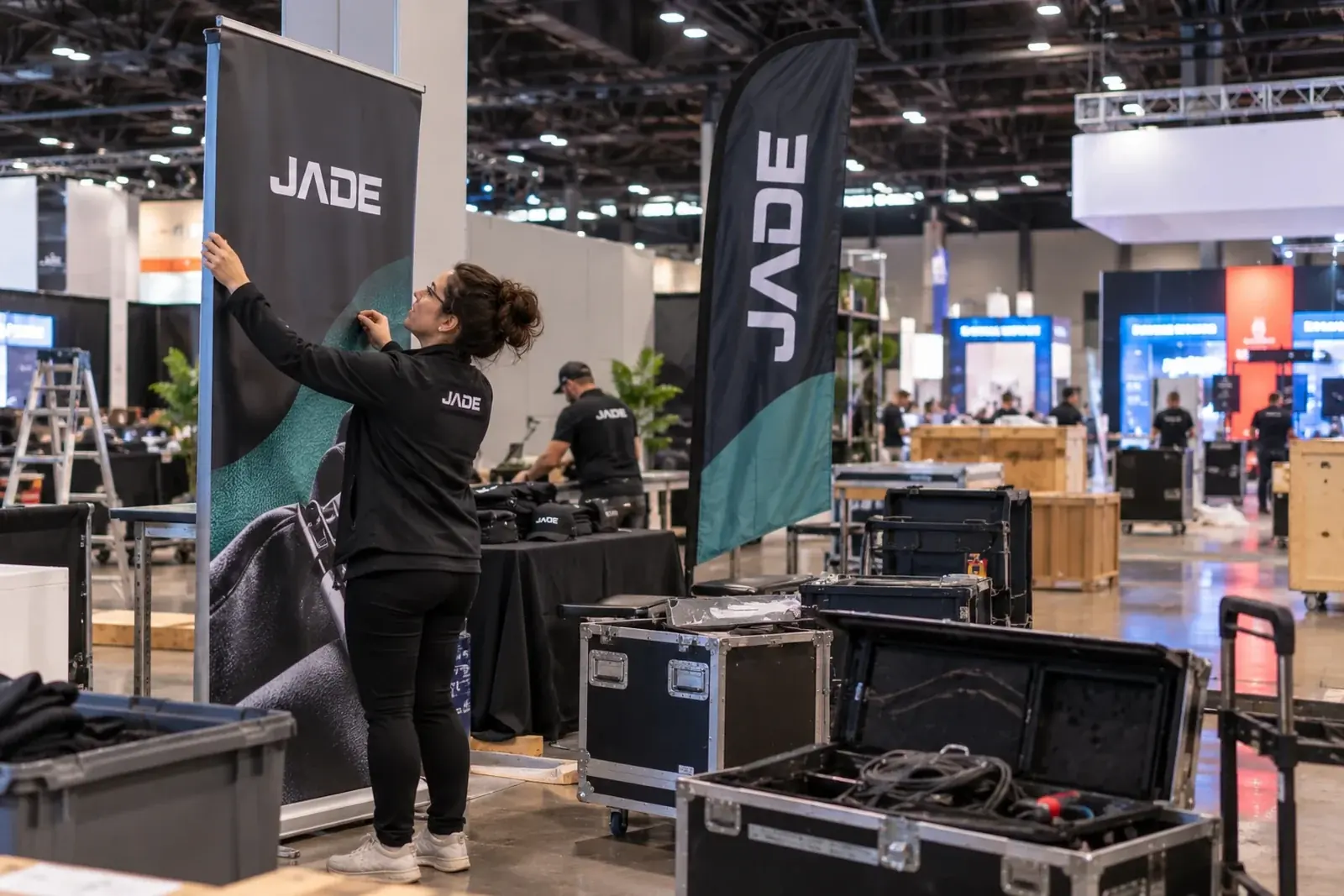 Employée installant une bannière Créations Jade dans un salon
