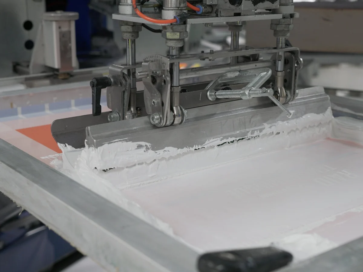 Raclage de l'encre sur une soie de sérigraphie